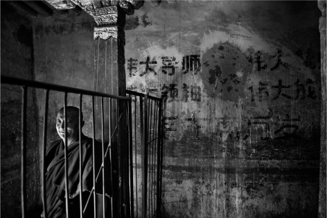 Laurent Zylberman, A Journey in Tibet, A monk near a slogan to the Glory of Mao Zedong at Drepung Monastery, 2008, Sous Les Etoiles Gallery