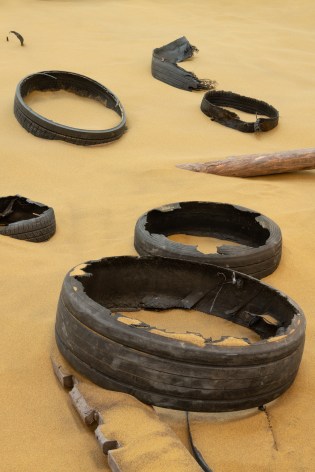 Installation view of Mike Nelson, Triple Bluff Canyon (the woodshed), 2004. Various materials. M25, 2023., Found tyres. Photo: Matt Greenwood. Courtesy the artist and the Hayward Gallery.