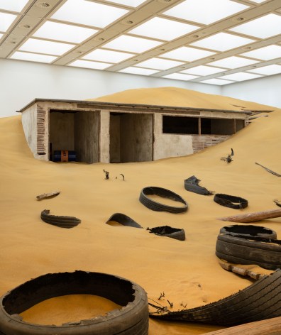 Installation view of Mike Nelson, Triple Bluff Canyon (the woodshed), 2004. Various materials. M25, 2023., Found tyres. Photo: Matt Greenwood. Courtesy the artist and the Hayward Gallery.