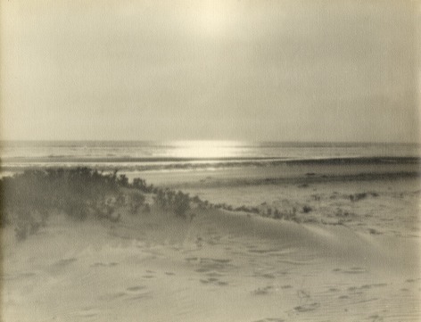 Warm toned photographic seascape with natural beach and dunes in foregournd.