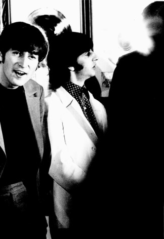 Black and white image from a Beatles press conference in 1966. John Lennon and Ringo Starr laughing.