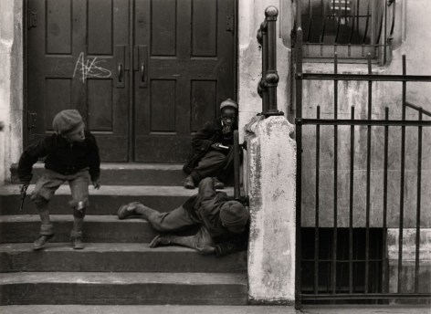 Black and white photo of three black boys playing cops and robbers on a NYC stoop.