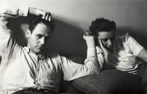 Black and white photo of James Agee reclining with his wife Mia, their hands touching.