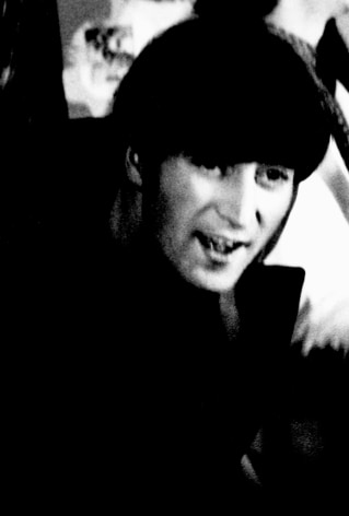 Black and white image from a Beatles press conference in 1966. Close-up of John Lennon.