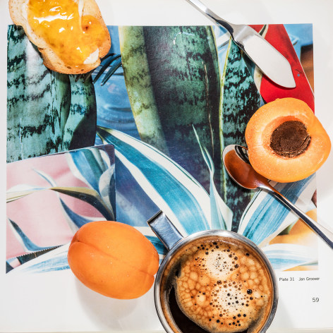 Toast with marmalade, peaches, and a cup of coffee&mdash;on top of an open photo book showing a photograph by Jan Groover.
