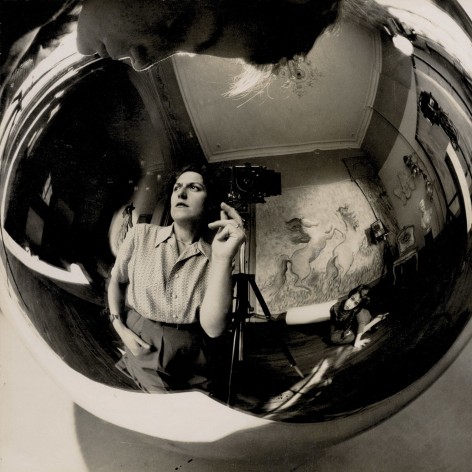 Black and white photo of a reflecting ball showing a distroted reflection of the photographer taking her self portrait with two children.