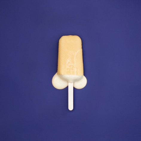 Colorful photo of a melting popsicle on a solid blue background.