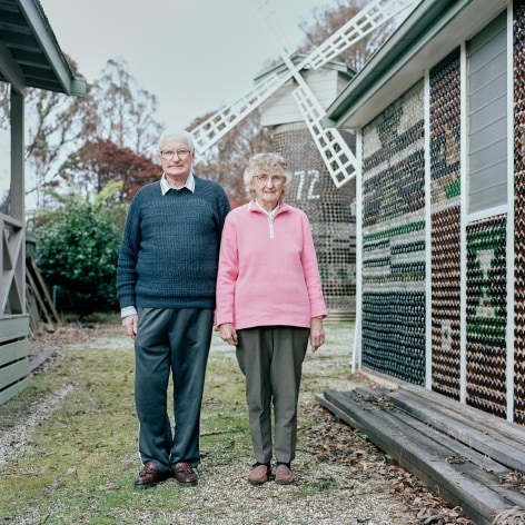Color photo of man and woman posing outside