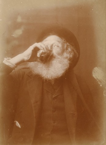 Warm toned photo of an old bearded man, enthusiastically drinking wine from a glass.