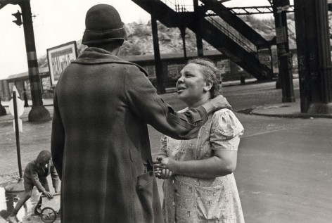 Black and white photo of a woman comforting another woman under an elevated train Laine in NYC.