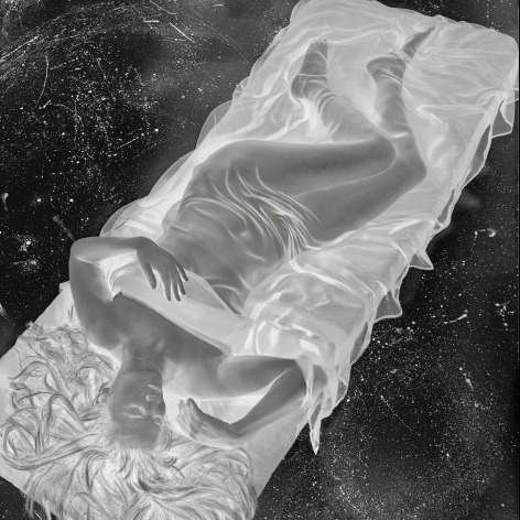 Negative image of woman, nude except for a transparent sheet, reclining on a mattress.