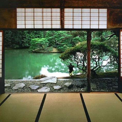 Color photo of a view of a Japanse garden and pond, looking out from the interior of a traditional Japanese villa.