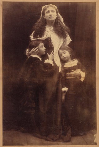 19th century black and white photo of a mother embracing her two young chiildren.