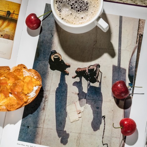 Toast with marmalade, cherries, and a cup of coffee&mdash;on top of a an open photo book showing work by Ernst Haas.