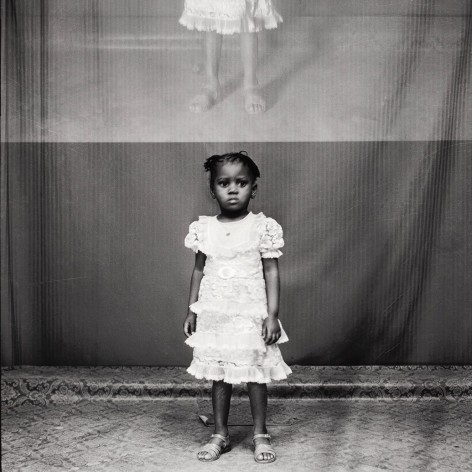 Black and white photo portrait of a young black girl in a white dress, with double exposure