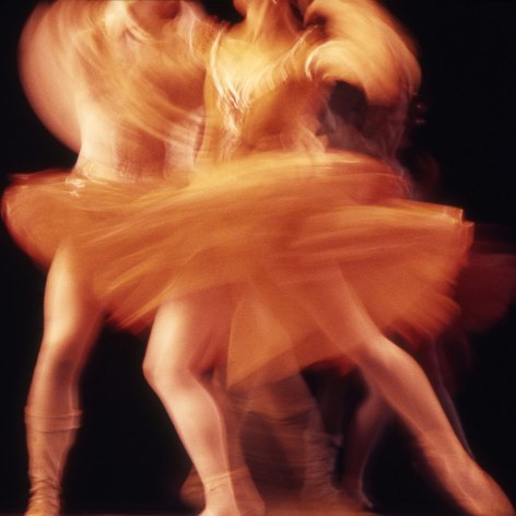 Color photograph showing a close cropped imae of swirling ballet dancers with motion blur.