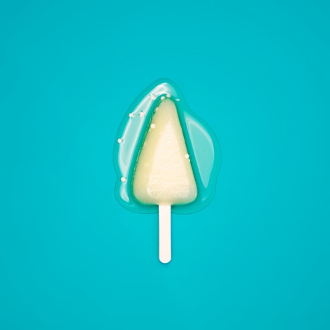 Color photo of a popsicle melting on a greenish blue background.