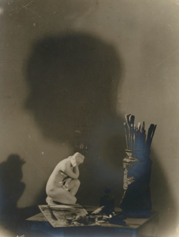 Black and white photographic still life with a shadow showing a man in profile.