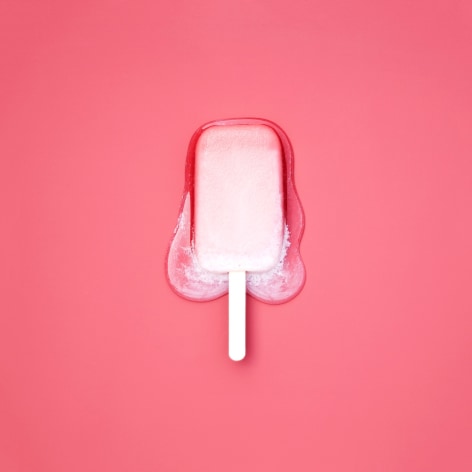 Color photo of a pale pink popsicle melting on a darker pink background.