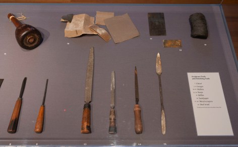 Close up image of the encased wooden sculpture tools and equipment featured in the exhibit.
