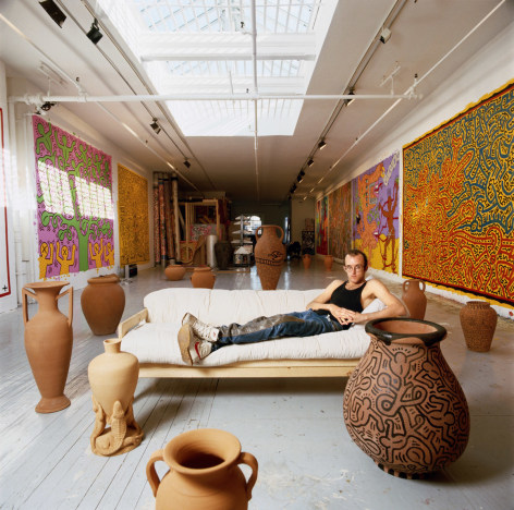 Keith Haring on couch, New York studio,&nbsp;1988. Chromogenic print, 19 1/2 x 19 1/2 inches.