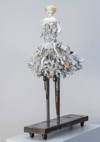 Karin Broker Shotgun girl, 2021 shotguns, porcelain, ceramics, glass, button, wire, steel base 39 1/2 x 21 x 18 1/2 inches