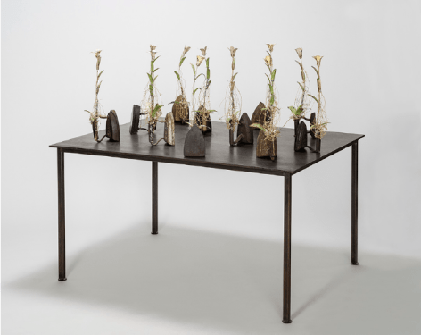 Karin Broker  Second Wives, 2018  11 antique irons, wired metal flowers with crystals on steel table  44.5 x 48 x 36 inches  Inquire