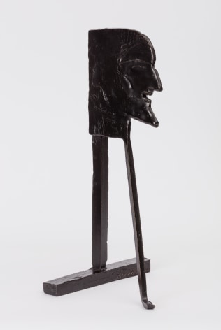 bronze statuette of a man's face on two long supports