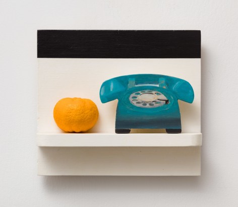 a phone and an orange on a painted white and black shelf