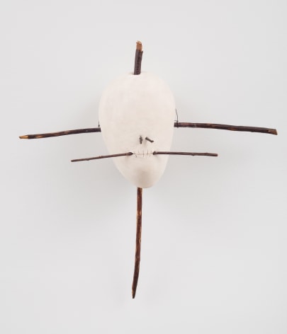 a ceramic skull that is crucified with wooden sticks