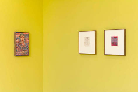 installation view of multiple works on paper and paintings in a yellow room