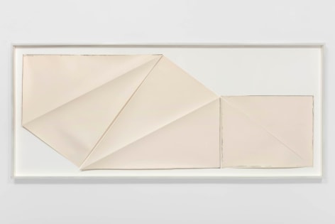 multiple pieces of paper that have been folded and cut put into a frame on a white boad