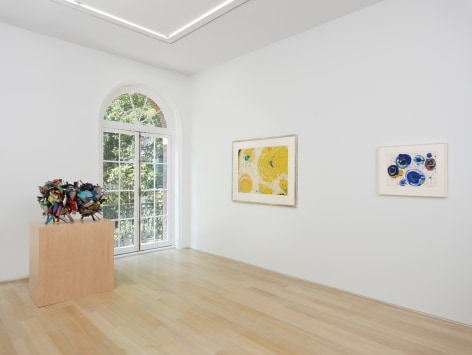 installation view of two framed works on paper with a sculpture in the foreground