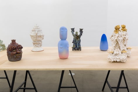 An installation view of the group exhibition &quot;Morph&quot;. There are many sculptures on a table in the gallery