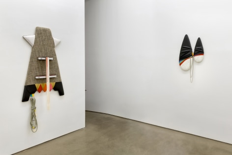 Installation view of Trish Tillman's exhibition &quot;Stage Diver&quot;, which shows plush sculptures on the walls by a doorway