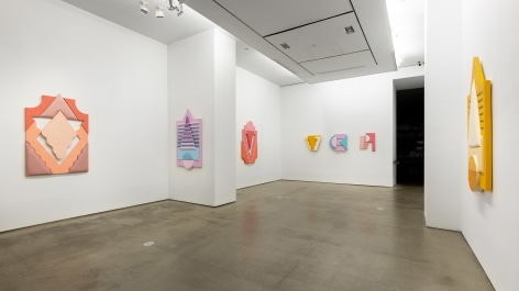 Installation views of Leah Guadagnoli's solo exhibition. Geometric sculptures made from fabric, foam, and pumice stone line the walls.
