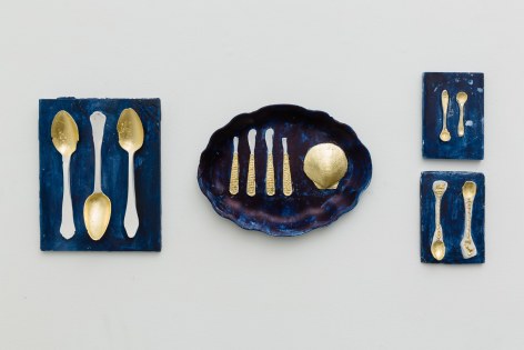 An installation view of artwork by Julie Schenkelberg. Mixed media pieces silverware casts line the walls