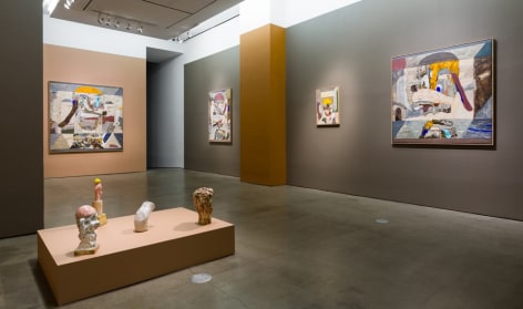 An installation view of paintings and sculptures by Gudmundur Thoroddsen. Large and medium paintings are hung on the wall by ceramic sculptures on pedestals.