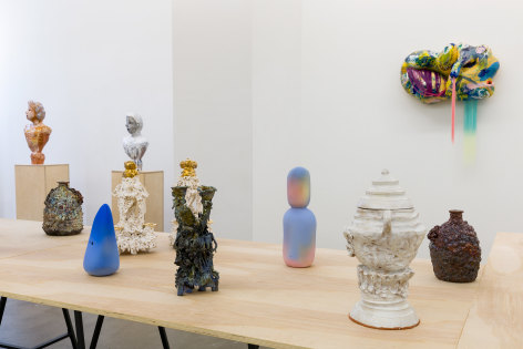 An installation view of the group exhibition &quot;Morph&quot;. There are many sculptures on a table in the gallery