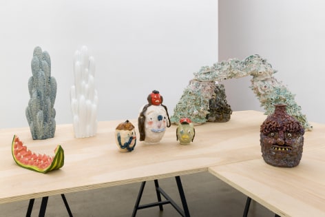An installation view of the group exhibition &quot;Morph&quot;. There are many sculptures on a table in the gallery