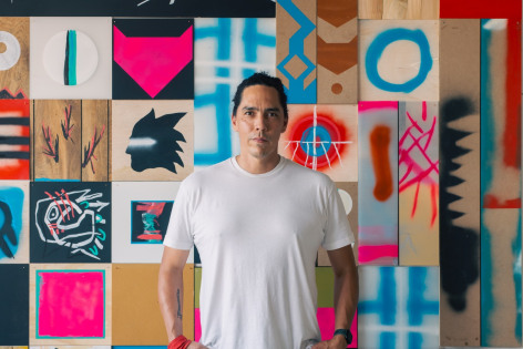 Artist Matthew Kirk standing in front of one of his paintings