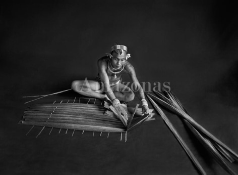 , Sebasti&atilde;o Salgado. Teureum, sikeirei (shaman), leader of the Mentawai clan, preparing a filter for sago. Siberut Island. 2008. Gelatin silver print. 180 x 125 cm.