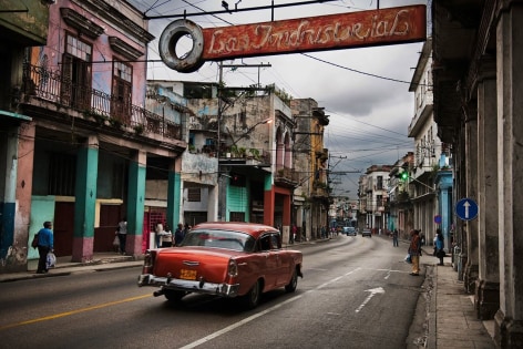 Steve McCurry, A red car driving through the streets of Havana, Cuba, 2010, ultrachrome print, 76.2 x 101.6 cm (30 x 40 inches)