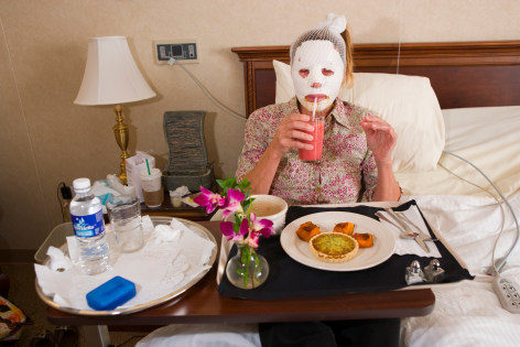 Dr. Steven Teitelbaum&rsquo;s forty-nine-year-old patient, who is recovering from a full-face laser resurfacing and an upper eye lift, eats lunch in a private room at Serenity, a luxury aftercare facility that offers private chefs, spa treatments, and twenty- four-hour nursing, Santa Monica, California, 2006, Archival Pigment Print