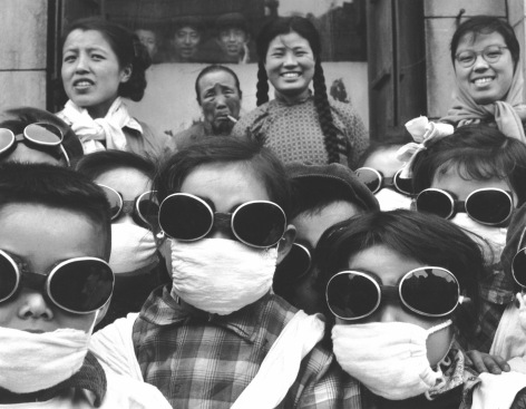 Schoolgirls wearing face masks and googles (to protect them from sand from the Gobi Desert), China, 1957