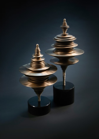 two small bronze sculptures by Elizabeth Turk of discs layered and arranged to resemble Modernist abstractions and a sound waves
