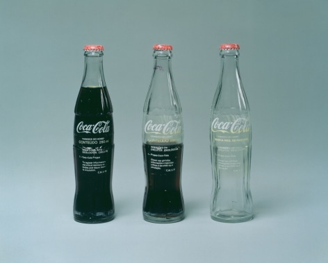 Cildo Meireles  Insertions into Ideological Circuits: Coca-Cola Project, 1970  Three glass bottles, metal caps, liquid, and adhesive labels with text  Each: 7 inches (24.1 x 17.8 cm)