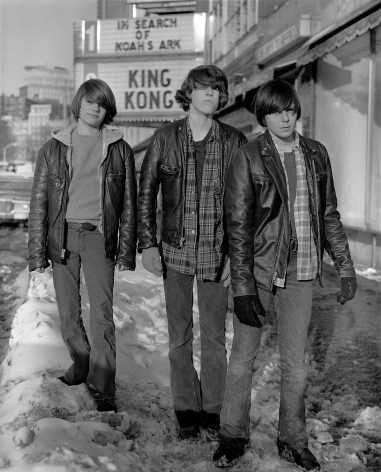 1970s black and white photograph of three teenage boys on snowy city sidewalk with movie theater marquee