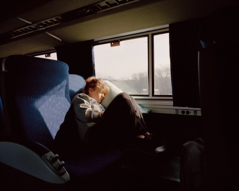 Person seated on train, by McNair Evans