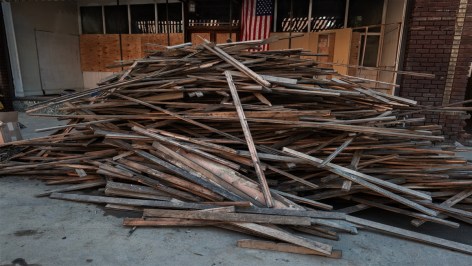 a pile of floor plank sits outside of an antiques market destroyed by flood waters in Marshall, North Carolina